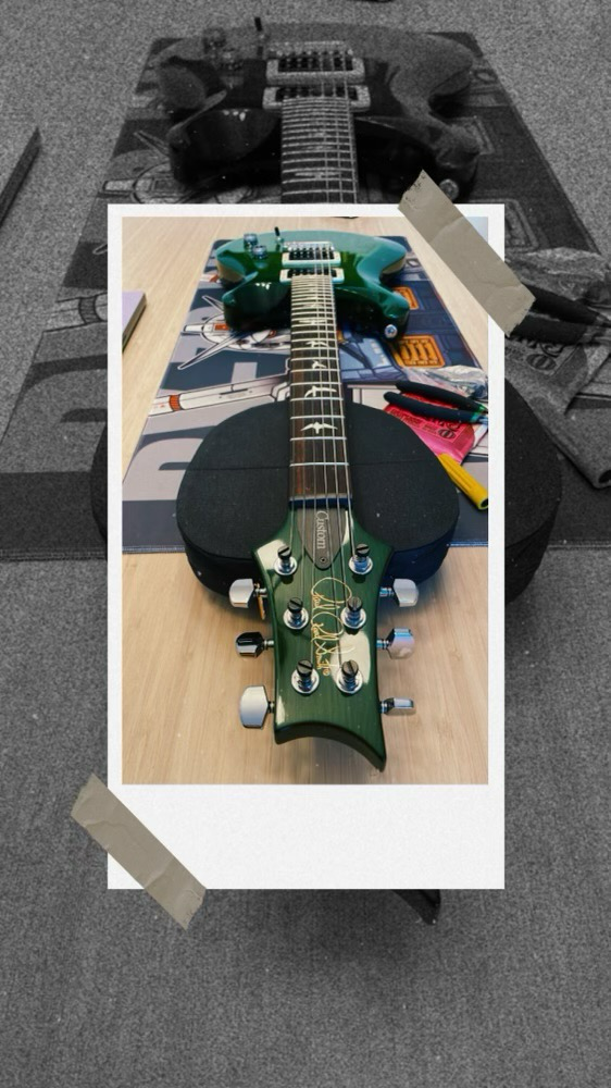 PRS green coloured guitar on a table
