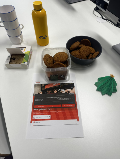 Table with cookies, cookie notice, NS coffee bottle, sugar, cups and a 3d printed Christmas tree