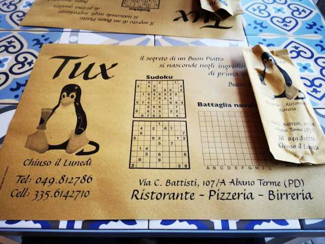 Tovaglietta del menu della pizzeria "Tux" con il logo di GNU/Linux.