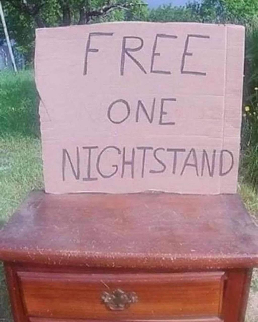 A sideboard table outside on a lawn with a large sign that reads: FREE 
ONE 
NIGHTSTAND