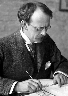 J.J. Thomson, Nobel Prize photograph (1906).

Nobel foundation - http://nobelprize.org/nobel_prizes/physics/laureates/1906/thomson-bio.html

Joseph John Thomson (1856–1940), often referred to as J.J. Thomson, is shown in a candid pose, engrossed in writing or drawing, likely related to his scientific work.

He is depicted as a middle-aged man with receding hair, a neatly groomed mustache, and a composed, intellectual demeanor.

Thomson is wearing formal attire typical of the early 20th century:
A dark tweed suit jacket with a subtle texture.

A high-collared white shirt and a decorative tie or cravat.

A pocket square neatly tucked into his breast pocket, adding to the formal appearance.

He is wearing round spectacles, which were characteristic of the period and contributed to his scholarly appearance.