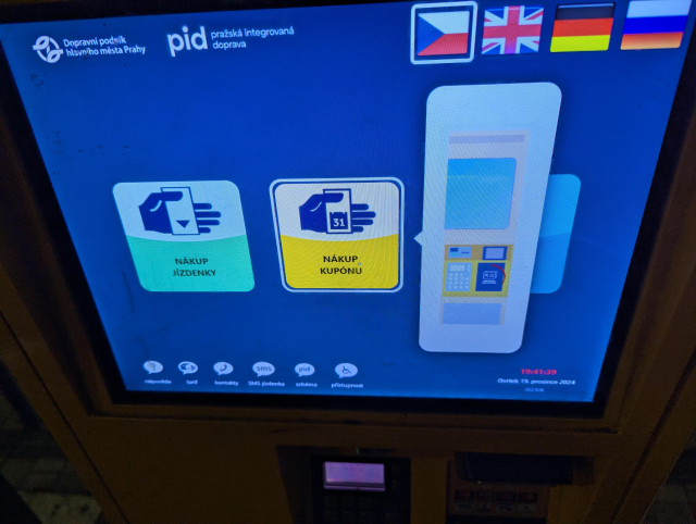 Obrazovka prodejního automatu. Uprostřed je velké tlačítko „nákup kuponu“ a obrázek, kam je třeba přiložit identifikátor.