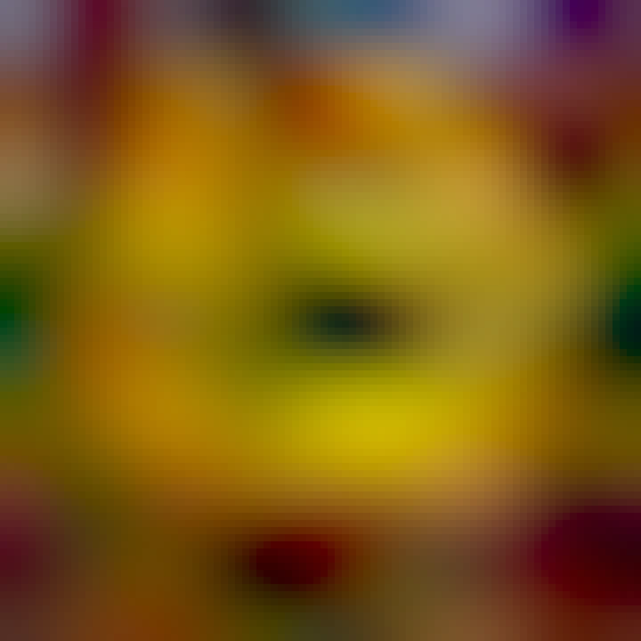 Yellow dahlia with red tips. Green foliage and blue sky in the background. 