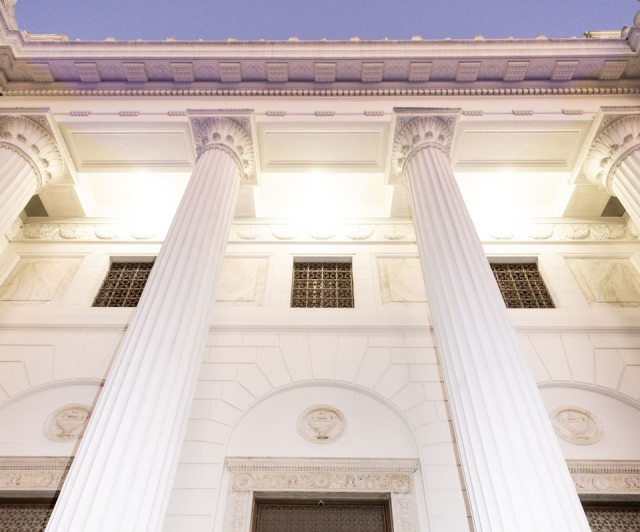 Photo of the Internet Archive at dusk, showing illuminated white columns.