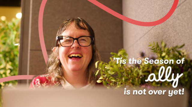 Smiling woman wearing Envision Glasses sits near vibrant green plants, framed by a red looping design. The text reads, '’Tis the Season of ally is not over yet.'