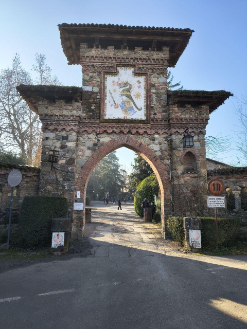 Porta d'ingresso a Grazzano Visconti, un arco in muratura sovrastato da un affresco che rappresenta lo stemma Visconti: il drago Tarantasio che mangia un bambino