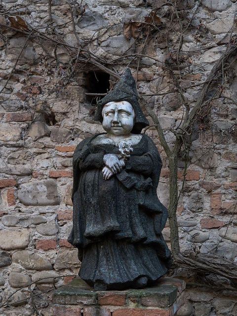 Una statua di Eloisa, il fantasma che infesterebbe il castello di Grazzano Visconti. La statua rappresenta una donna tarchiata vestita di nero.