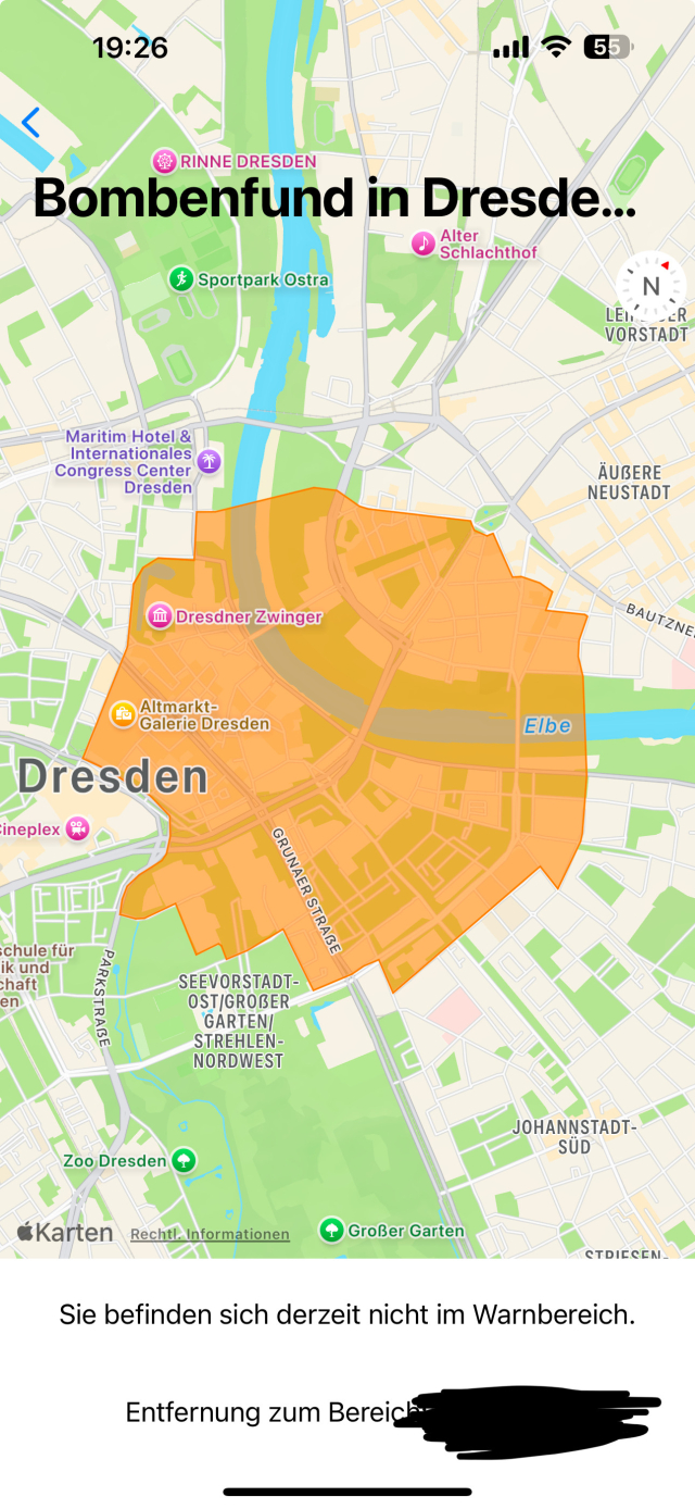 Eine iOS-Anwendung, die den Warmbereich einer NINA-Warnmeldung anzeigt, hier den aktuellen Bombenfund in Dresden. Dazu die Information, dass ich mich gerade nicht im Warnbereich befinde, sowie die Distanz dorthin. Die Distanz ist im Screenshot geschwärzt.
