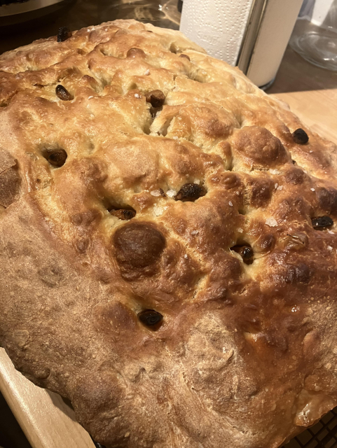 A pan of focaccia bread, with garlic confit and sea salt flakes on top
