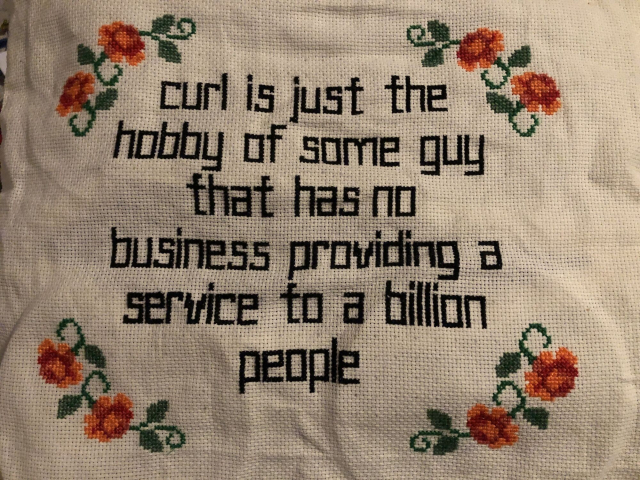 Wrinkly Aida cloth, centered: 
„curl is just the
hobby of some guy
that has no
business providing a 
service to a billion
people“
The text is cornered by four floral arrangements in red.