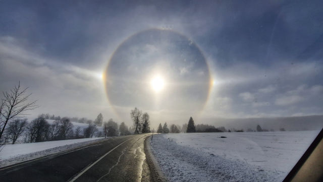 Halový jev nad zimní krajinou