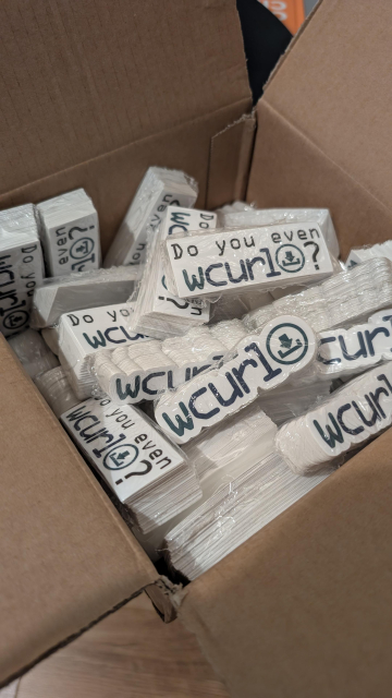 A box with lots of stickers with the wcurl logo, there are also stickers with "do you even wcurl?" written in them