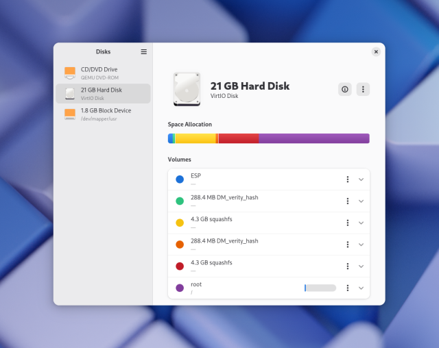 Medium-sized GNOME Disks window with the GNOME 48 wallpaper in the background. The app consists of a sidebar with 3 disks, and a main view with a colorful bar graph of the 6 partitions on the selected disk, and a listbox below showing more details on the partitions.

The app uses the latest Libadwaita style with split view, no raised headerbar, etc.