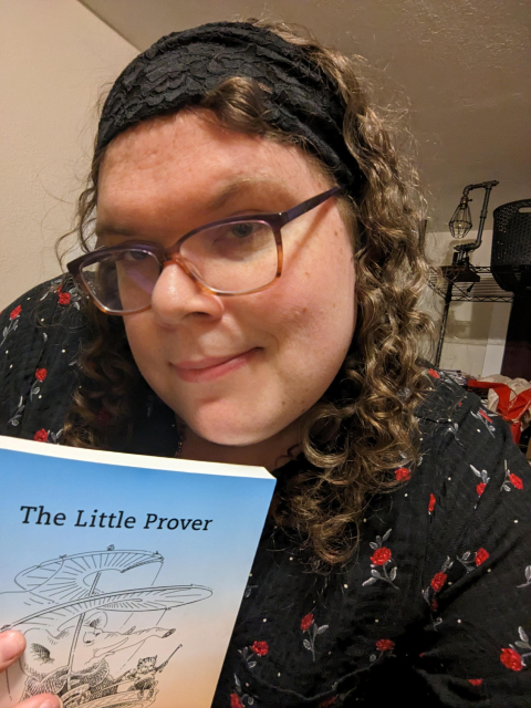 Christine holding a copy of The Little Prover