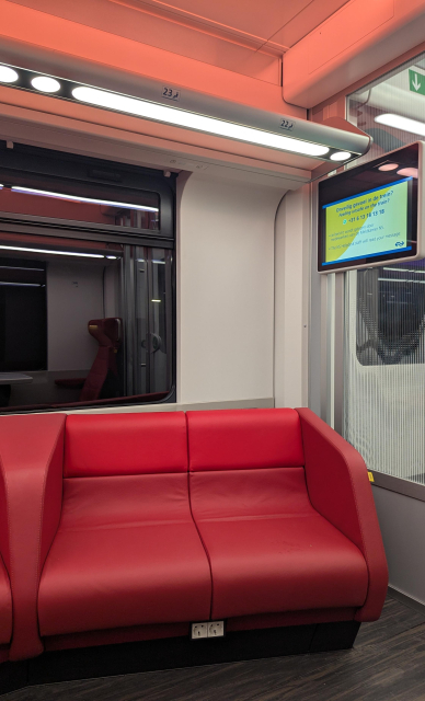 A picture of a sofa-like seat on a train. Above it, seat numbers 23 and 22 are displayed.