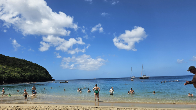 Beach filled with people not garbage.