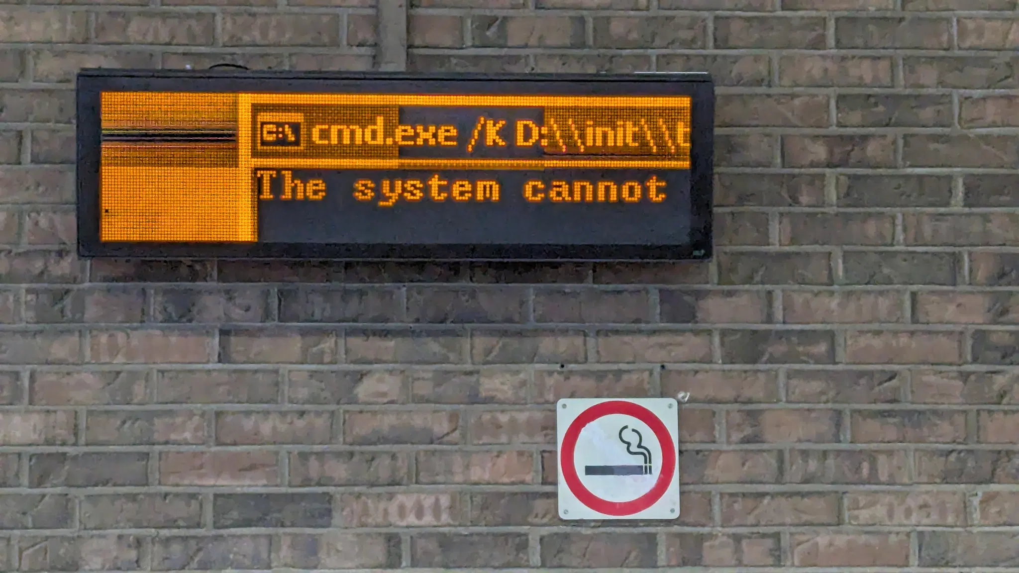 An electric sign that is clearly broken which reads:
"C:\ cmd.exe /K D:\\init\\t
The system cannot"