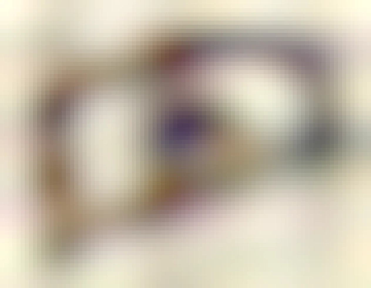 A picture of two slightly purple ceramic package PGAs typical of the early '90s. Each is a rectangle with a large complete square hole right through the middle, as no silicon was required for correct operation. One is pin side down on the desk, while the other is tilted at a fun angle sitting over the other, with gold pins pointed upwards.