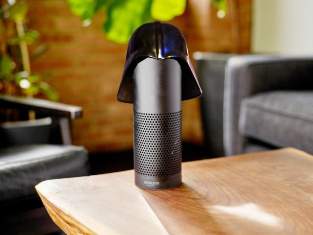 A cylindrical black Alexa speaker on a coffee table; it is wearing a Darth Vader helmet.

Image:
Stock Catalog/https://www.quotecatalog.com (modified)
https://commons.wikimedia.org/wiki/File:Alexa_%2840770465691%29.jpg

Sam Howzit (modified)
https://commons.wikimedia.org/wiki/File:SWC_6_-_Darth_Vader_Costume_(7865106344).jpg

CC BY 2.0
https://creativecommons.org/licenses/by/2.0/deed.en