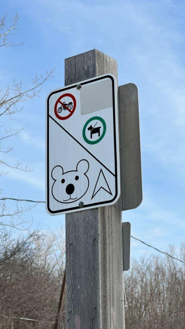 A park sign with a drawing of a teddy bear