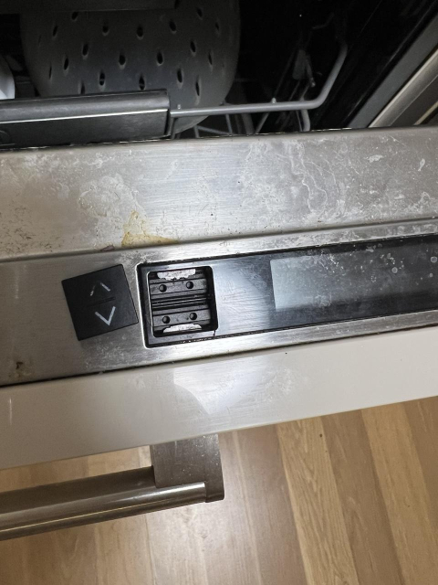 Špinavá rozbitá myčka s rozbitým tlačítkem.