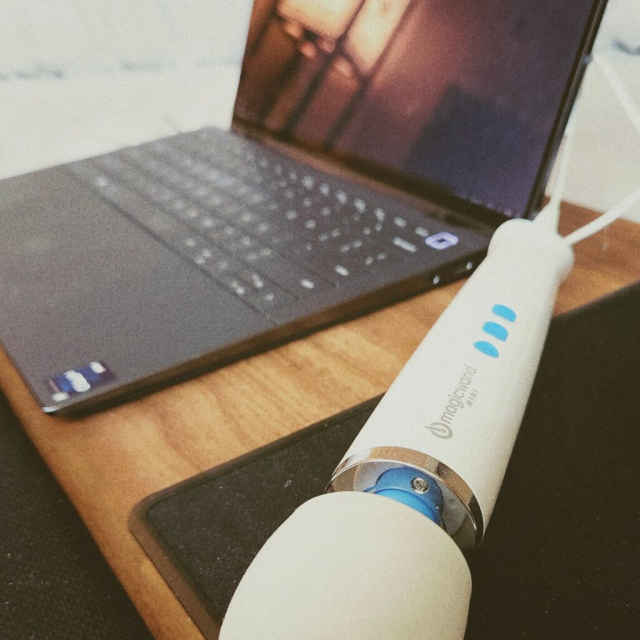 A photo of a "magic wand" personal vibrator next to a laptop