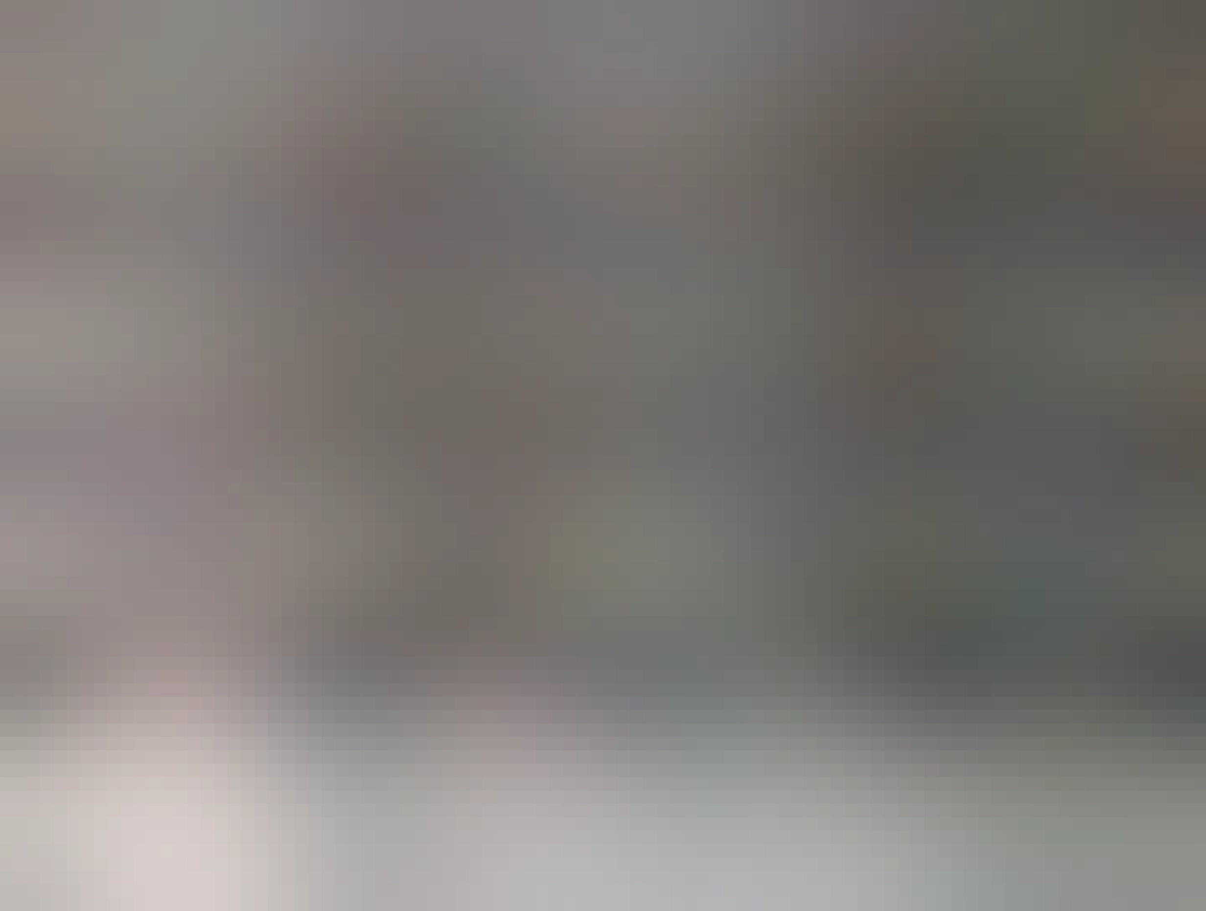 Фотография потолка внутри того же автомобиля такси. Потолок украшен тонкими гирляндами из разноцветных бусин и небольших шариков, расположенных по спирали от центра к краям, закрепленными на полотке с помощью булавок. В нижней части кадра дополнительно размещены несколько более крупных и блестящих шариков-подвесок разных цветов, таких как фиолетовый, синий, золотой, красный и зелёный. Украшение создаёт праздничную атмосферу внутри машины.