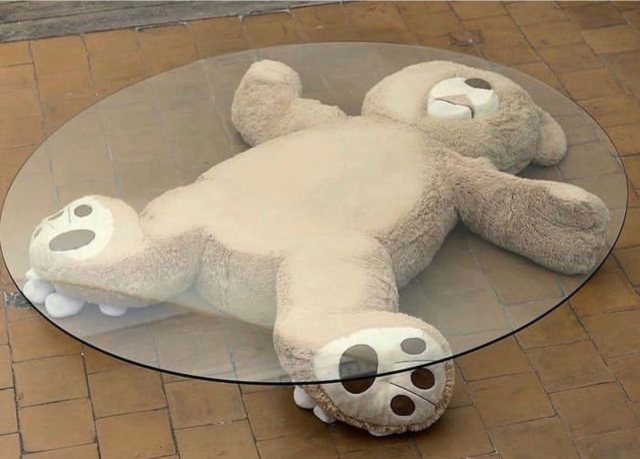 Fuzzy bear crushed under glass table top