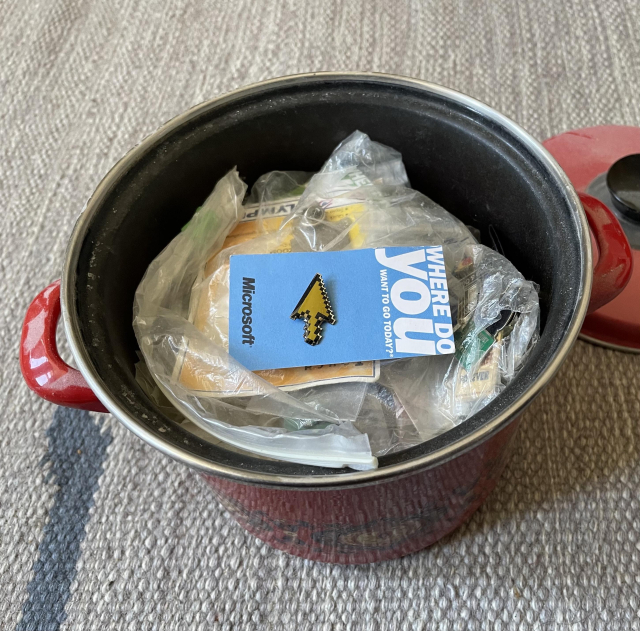 Pot filled with various pins, mostly IT and broadcasting related.