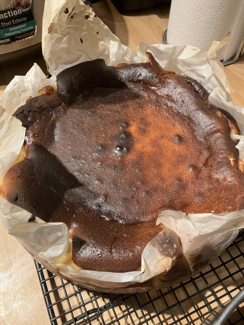 Burnt Basque cheesecake, in its tin, resting on a rack after baking in the oven for about 45 minutes