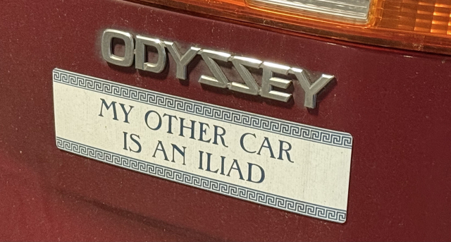 Back of a Honda odyssey with a bumper sticker that says “My other car is an Iliad”