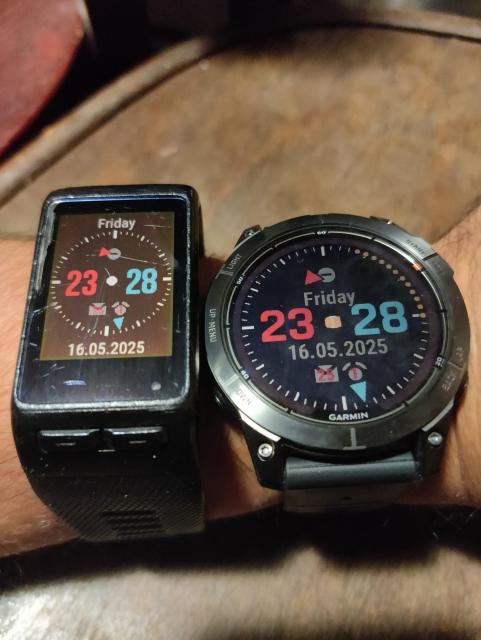 Two Garmin smart watches side by side, one is older Vivoactive HR, second is newer Fenix 7 Pro. Both running the same watch face.