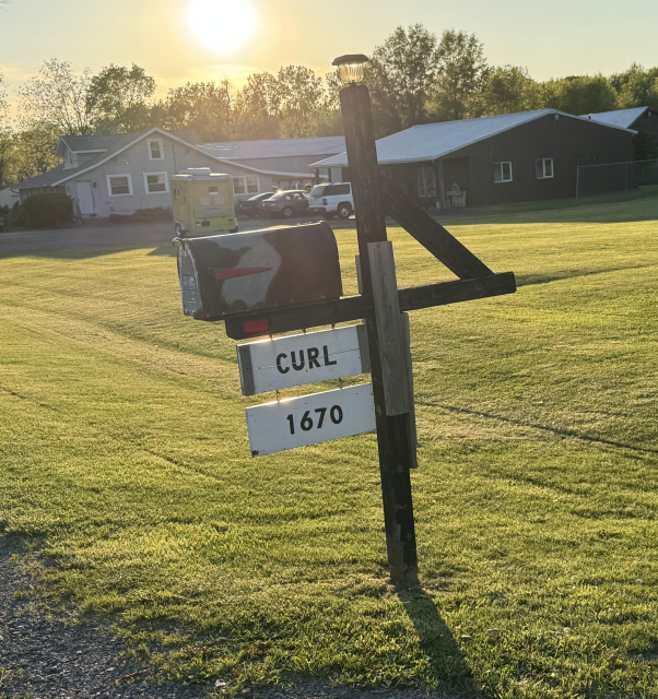 Midwestern United States mailbox with the word "CURL" on a sign.