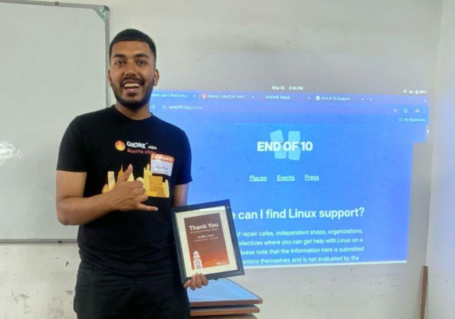 Aaditya Singh of GNOME Nepal, in front of an "End of 10" presentation explaining how to get support installing Linux on end-of-life Windows 10 laptops.
