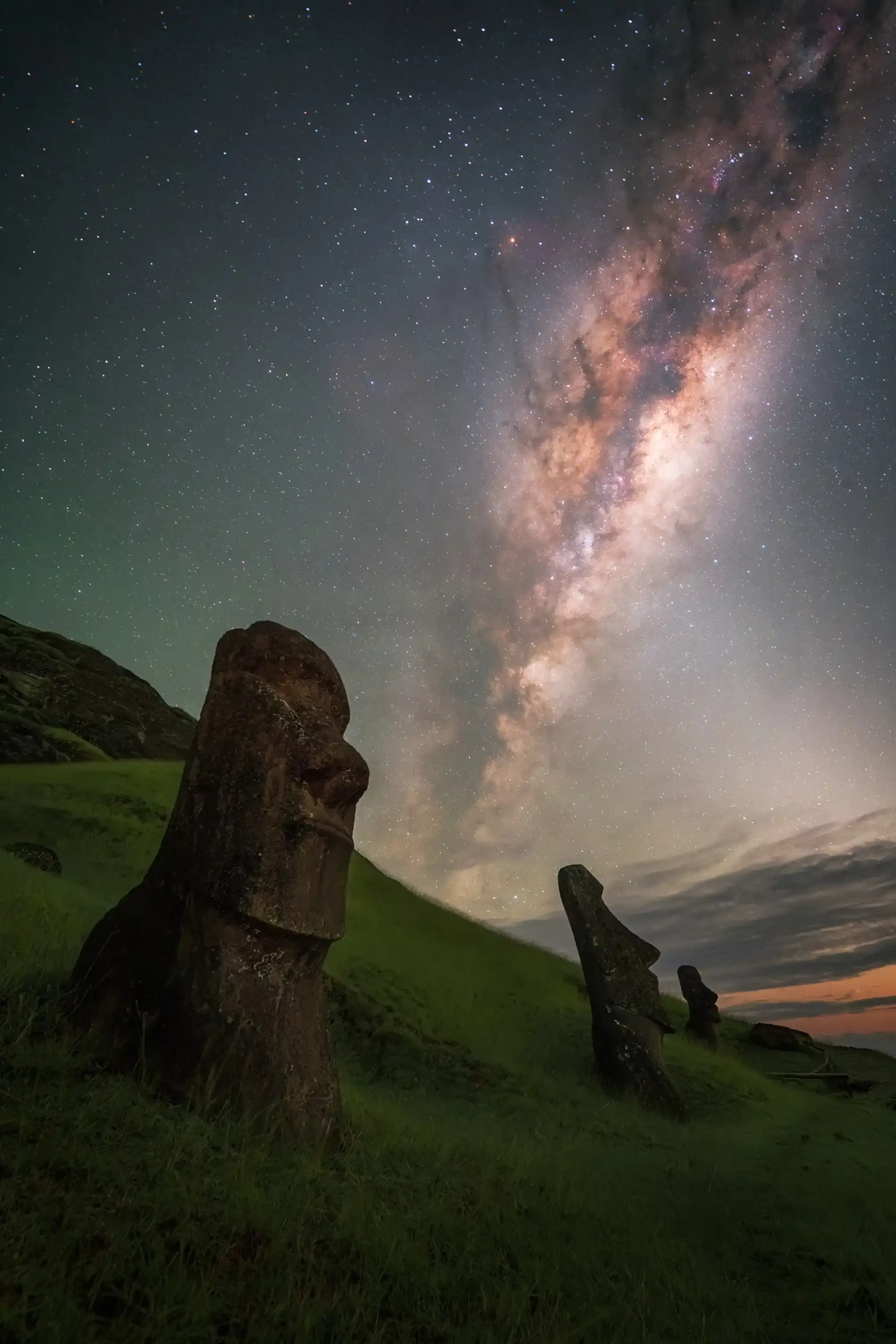 Giant statues on Easter Island, with Milky Way in the background.