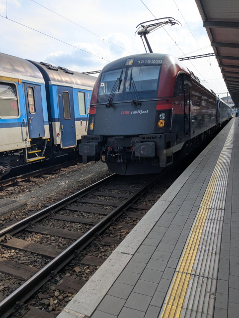 A RailJet of Austrian Railways arriving to a train station.