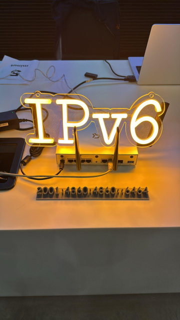 Turris Omnia with shining IPv6 label on top of it and 3D printed IPv6 address in front of it.