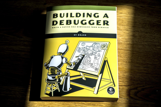 The book Building a Debugger, featuring a robot designing a complex debugging machine on a drafting board