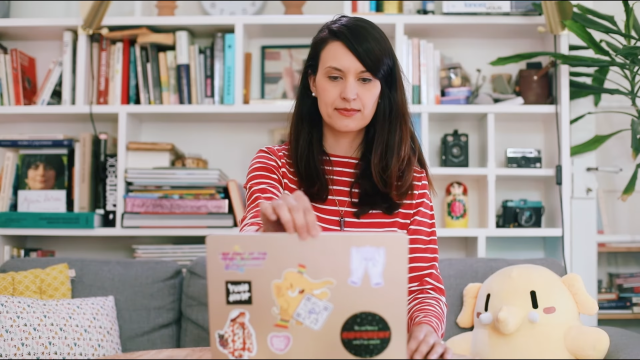 Still from the short film showing @_elena in a sofa opening a laptop. 