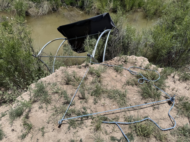 The image depicts a natural landscape with a body of water in the background, likely a river or lake, with murky greenish-brown water. In the foreground, there is a dirt embankment with sparse vegetation, including green shrubs and grasses. A metal structure, possibly part of a railing or support system, is partially visible, with one arm bent and the other extending towards the water. The structure appears to be damaged or broken, with one end embedded in the ground and the other end bent at an angle. The surrounding area shows signs of erosion, with patches of exposed soil and some small rocks. The overall scene suggests a natural environment that has been impacted by human-made structures.

Provided by @altbot@fuzzies.wtf, generated privately and locally using Ovis2-8B

🌱 Energy used: 2.574 Wh