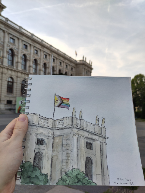A sketchbook showing an ink and watercolor sketch is held up by my hand. The sketch is a historic building with a pride flag on top. In the background is the real building.