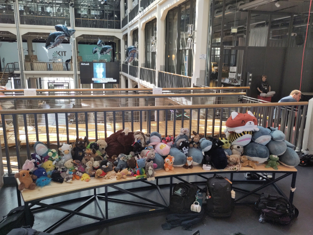 Hunderte Kuscheltiere auf einer Bank auf der GPN. Darunter sehr viele Blåhajs.
