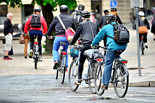 a picture of several people cycling in a city street.