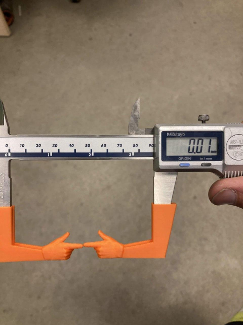 A caliper with some plastic attached to each end that resemble 2 fingers pointing and touching each other.