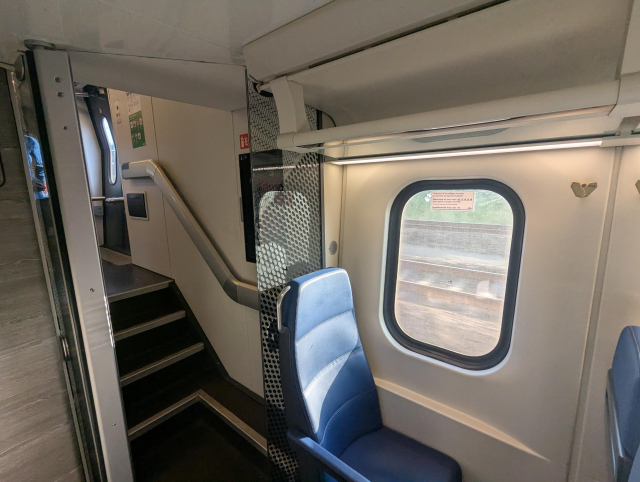 A view of a part of the interior of a train. Small details like seats or hangers show that this is the newest modernisation.