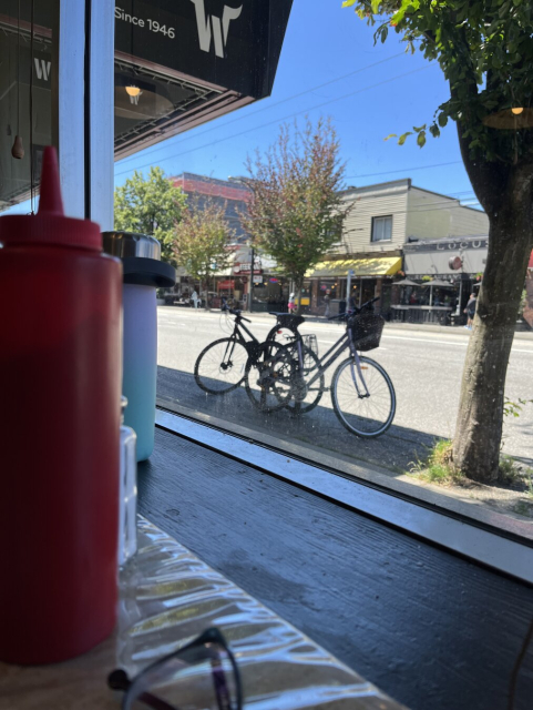 Parked bikes in front of the street, photographed from behind a diner’s window