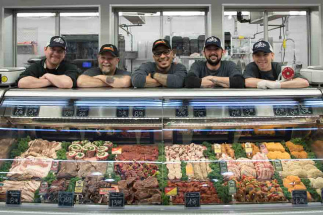 5 Meat guys standing behind the display case 