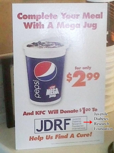 This image shows a promotional sign, likely inside a KFC restaurant, advertising a large Pepsi soft drink called a “Mega Jug” for $2.99.

The sign says:
“Complete Your Meal With A Mega Jug — for only $2.99”

Below the drink image, it states:
“And KFC Will Donate $1.00 To JDRF” (which stands for Juvenile Diabetes Research Foundation — this is spelled out in a small box next to the acronym).

At the bottom, it says in big red letters:
“Help Us Find A Cure!”

The irony here is that it’s promoting a giant sugary soda, which contributes to diabetes risk, while claiming that a portion of the sale will go to a diabetes research foundation.