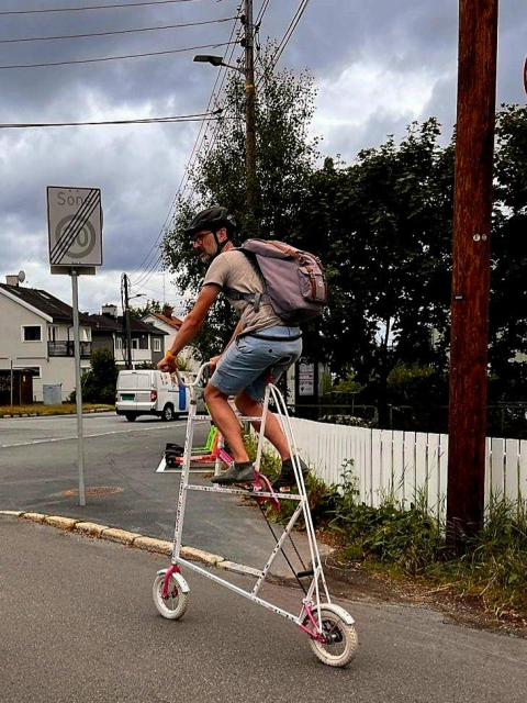 Man on a mini lamplighter bicycle. 