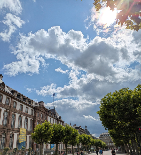 place Broglie, le soleil derrière les nuages, le ciel est encore bleu.